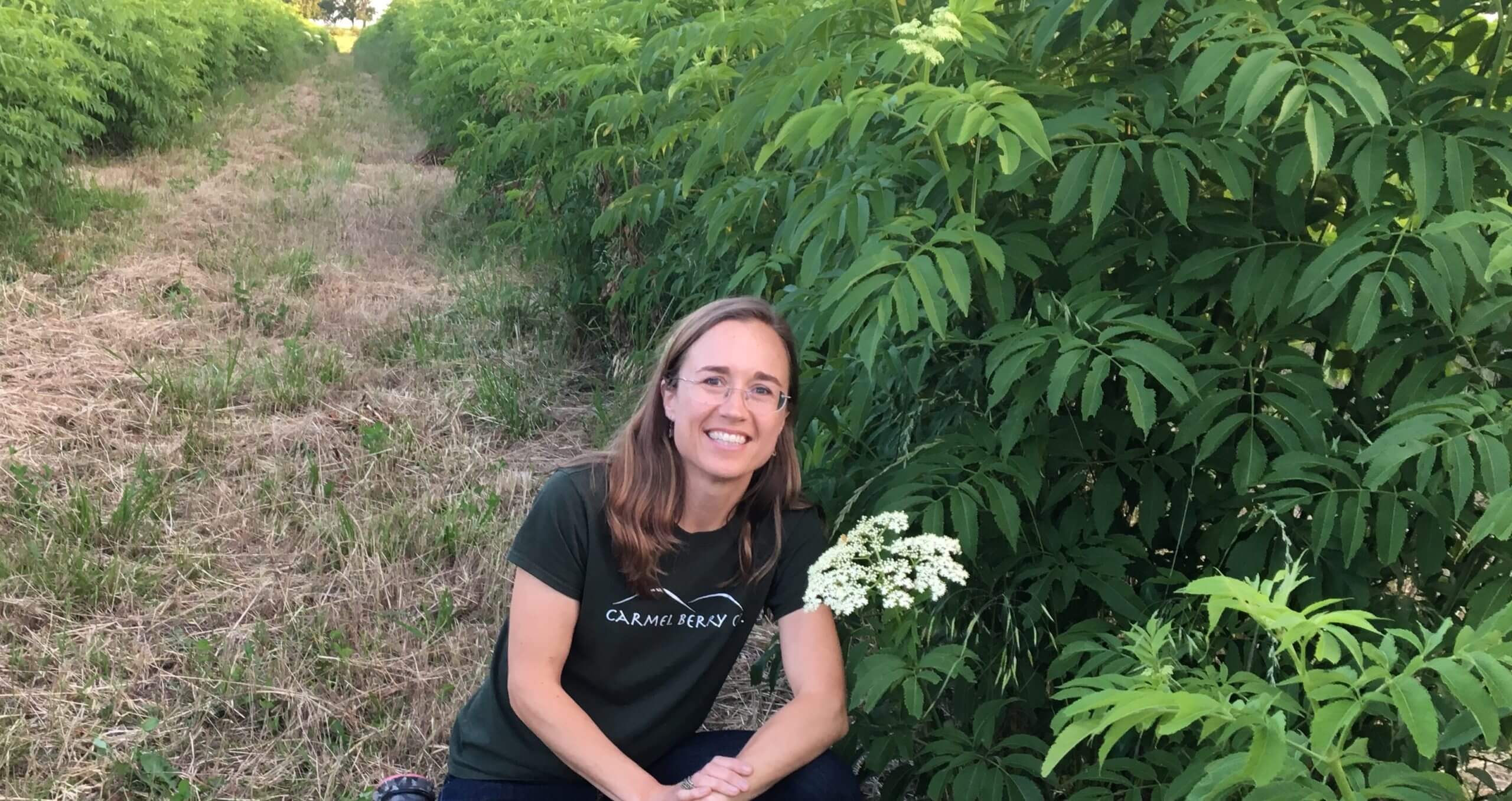 Carmel Berry Founder Katie Reneker with elderflower in field
